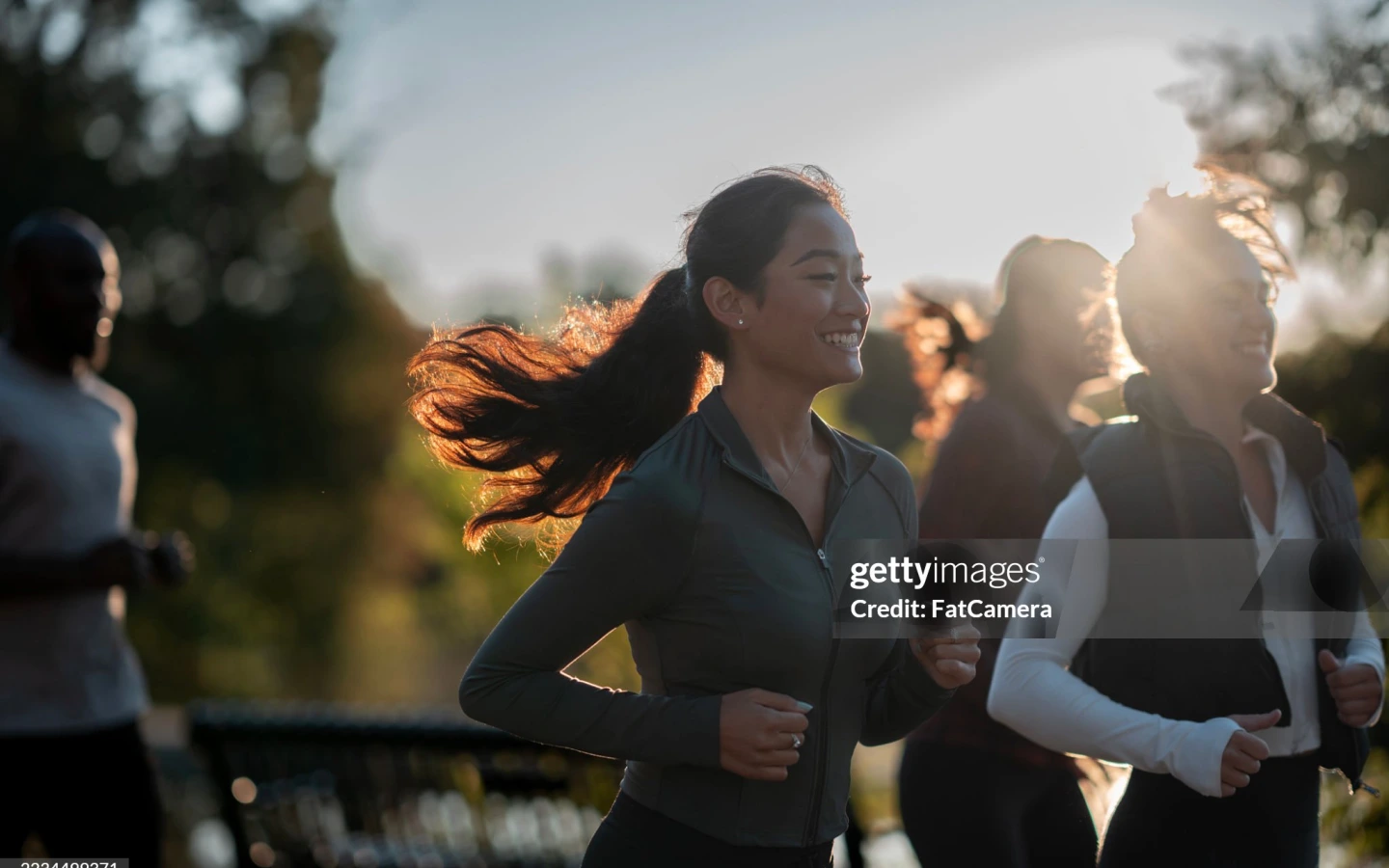 夕日の中、仲間と走る女性ランナーたち